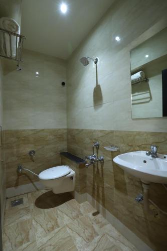 a bathroom with a toilet and a sink at Hotel Loyal Residency in Jamnagar
