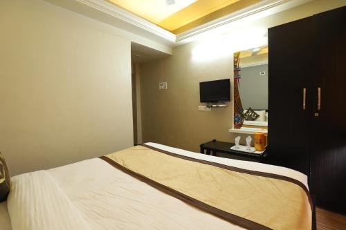 a hotel room with a bed and a mirror at Hotel Loyal Residency in Jamnagar
