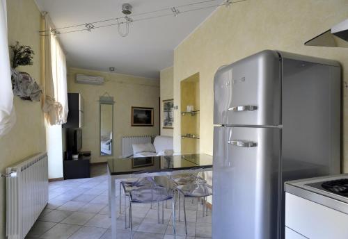 una cucina con frigorifero in acciaio inossidabile e tavolo di Palazzo Bertazzi a Verbania