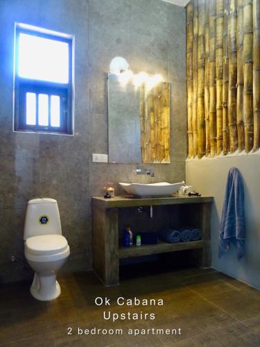 a bathroom with a toilet and a sink and a mirror at Ok Cabana Negombo in Negombo
