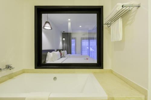 a bathroom with a large mirror over a bath tub at Aroma Angkor Boutique Hotel in Siem Reap