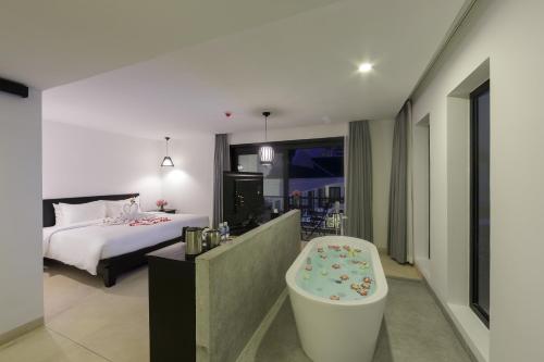 a bedroom with a bed and a bath tub in a room at Aroma Angkor Boutique Hotel in Siem Reap