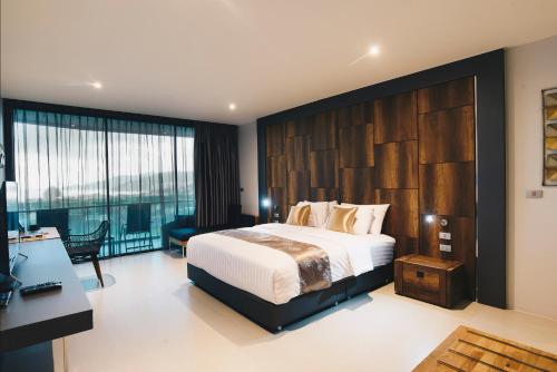 a bedroom with a large bed and a desk at Searocco Phuket in Patong Beach