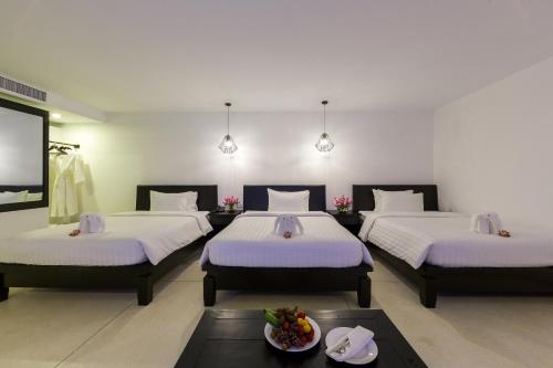 a room with three beds and a flat screen tv at Aroma Angkor Boutique Hotel in Siem Reap