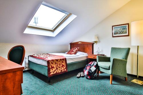 Schlafzimmer mit einem Bett, einem Schreibtisch und einem Stuhl in der Unterkunft Parkhotel Krone in Bensheim