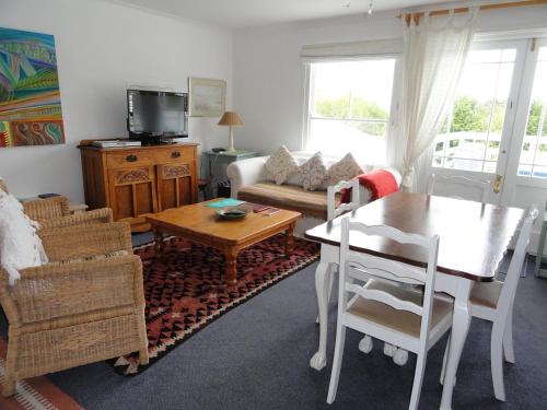 a living room with a table and a couch at Eastbury Cottage in Hermanus