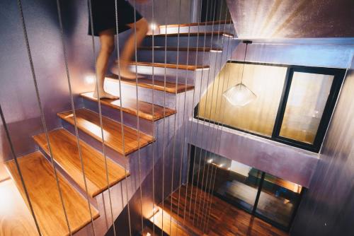 a person is walking on a wooden stairs at Searocco Phuket in Patong Beach