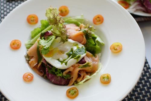 a plate with a sandwich with an egg and vegetables at Aroma Angkor Boutique Hotel in Siem Reap