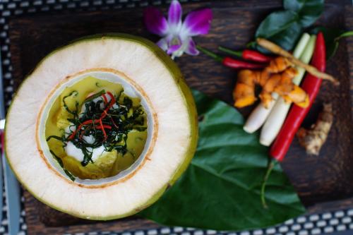 a papaya cut in half sitting on a table with vegetables at Aroma Angkor Boutique Hotel in Siem Reap
