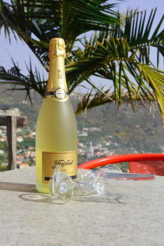 a bottle of champagne sitting on a table at Casa Horizonte in Arco da Calheta
