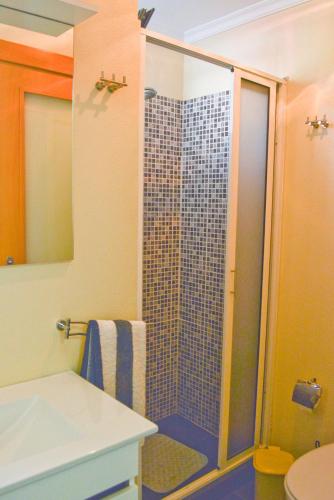 a bathroom with a shower with a sink and a toilet at Casa Horizonte in Arco da Calheta