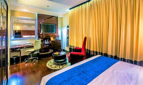 a hotel room with a large bed and a television at The Raintree Dhaka - A Luxury collection Hotel in Dhaka