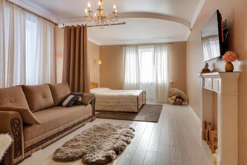 a living room with a couch and a bed at VIP квартиры на Московской by Sutki26 in Pyatigorsk
