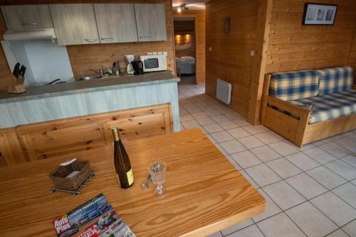 a bottle of wine on a wooden table in a kitchen at Les Adrets in Gérardmer