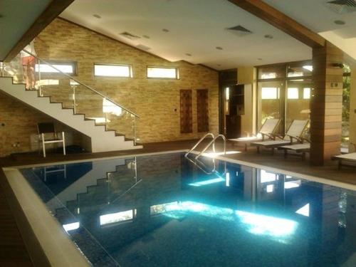 a large swimming pool in a building with a staircase at Lux Studio 45 in Fortuna in Bansko