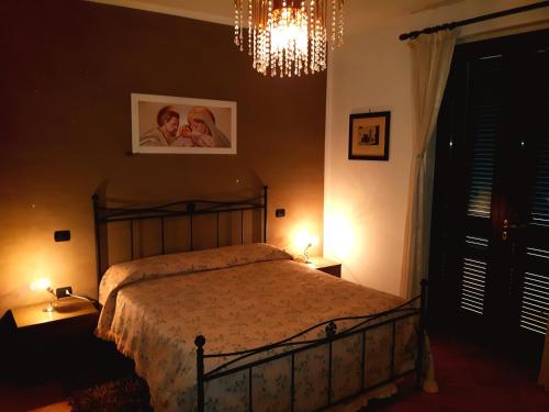 1 dormitorio con cama y lámpara de araña en Elisa House, en Foligno