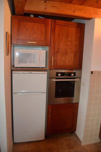 a kitchen with a white refrigerator and a microwave at Chata Dolce in Trutnov