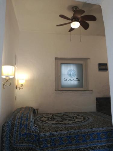 a bedroom with a ceiling fan and a bed at La Mirilla Suites 2 in Tarifa
