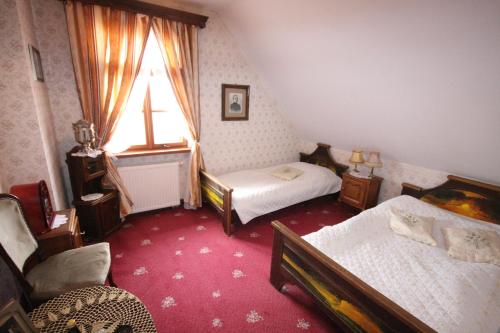a small bedroom with two beds and a window at Kiermusy Dworek nad Łąkami in Kiermusy