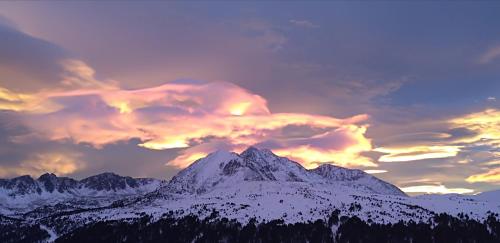 a mountain covered in snow under a cloudy sky at Hotel Mirtil in Pas de la Casa