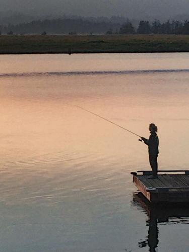a person standing on a dock fishing on a lake at Wheeler on the Bay Lodge and Marina in Wheeler