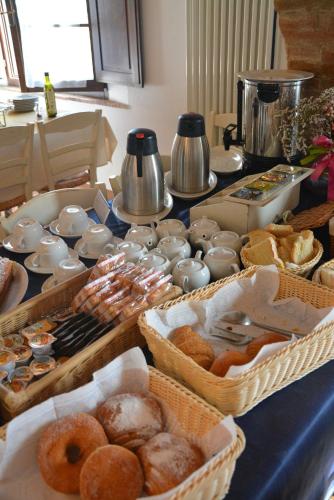 a table topped with baskets of different types of donuts at Casa Di Campagna In Toscana in Sovicille