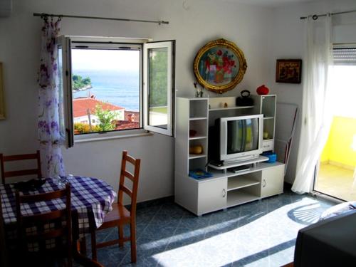 sala de estar con TV y ventana en Blue Sensation, en Okrug Donji
