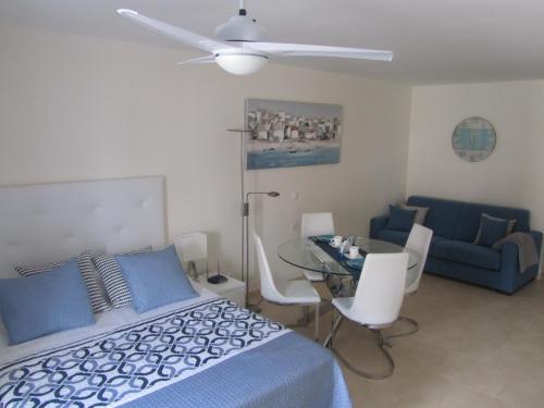 a bedroom with a bed and a table and a couch at Los Cristianos studio, modern, spacious, pool,WiFi in Arona