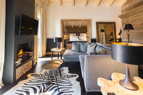 a living room with a couch and a fireplace at House of Hütter - Wachtelhof Hotel & Spa in Maria Alm am Steinernen Meer