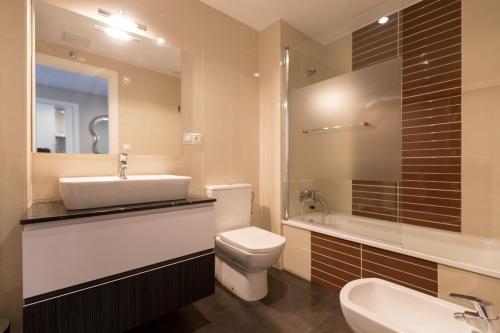 ein Badezimmer mit Waschbecken, Toilette und Badewanne in der Unterkunft Apartamento Playa Mar Portonovo Centro. in Sanxenxo