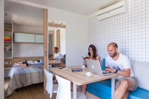 a group of people sitting at a table with a laptop at Riva Nuova Camping Village in Martinsicuro