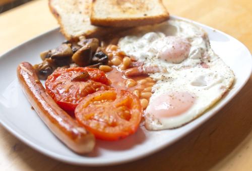 un piatto di prodotti per la colazione con fagioli e pane tostato di Pensjonat nad jeziorem Lakeside a Brodnica Dolna