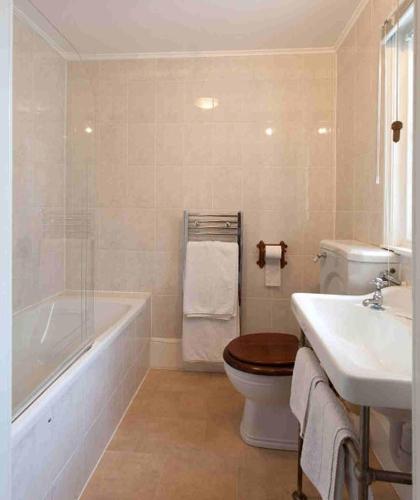 a bathroom with a tub and a toilet and a sink at Hollybank House in Emsworth