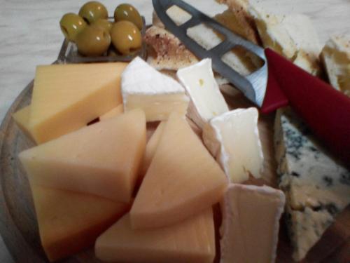a plate of cheese and grapes and a knife at Penzion Pomodoro in Vrbno pod Pradědem