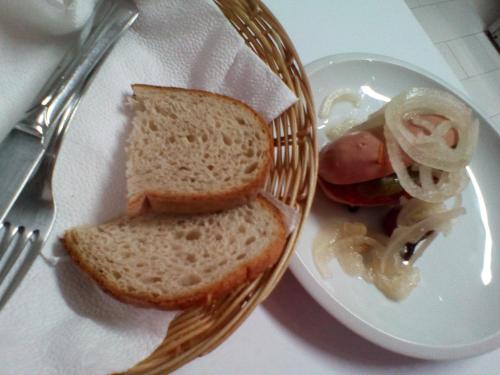 a plate with a sandwich and a hot dog and onions at Penzion Pomodoro in Vrbno pod Pradědem