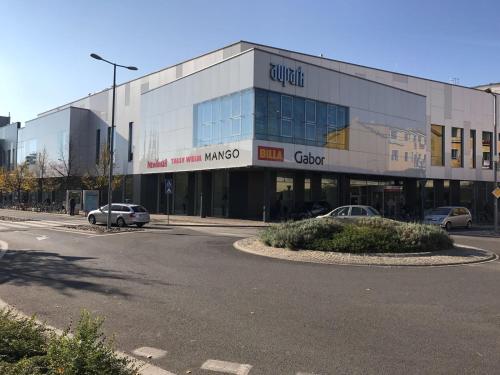 a large building with cars parked in front of it at Apartmán Centroom in Piešťany