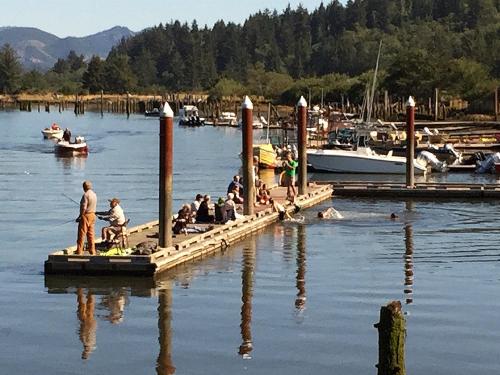 a group of people sitting on a dock in the water at Wheeler on the Bay Lodge and Marina in Wheeler