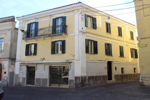 a yellow building with a man standing on a balcony at B&B Bouquet di fiori in Penne