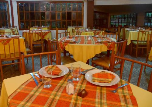 a dining room with tables with plates of food on them at Hotel Eo Park in San Clemente del Tuyú