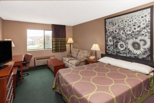 een hotelkamer met een bed en een bureau bij Super 8 by Wyndham Anamosa IA in Anamosa
