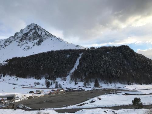 a snow covered mountain in front of a mountain at Helios 105 wifi et terrasse in Barèges