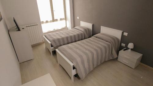 a room with two beds and a window at Casa Roncalli in Foligno