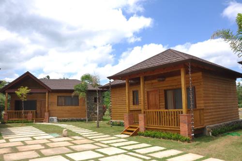a log cabin with a patio in front of it at Carmen Hotel & Villas in Jarabacoa