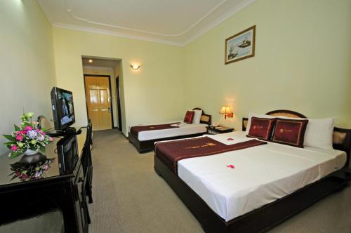 a hotel room with two beds and a television at Duy Tan Hotel in Hue