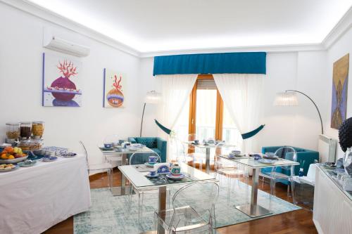 a white living room with tables and chairs at Isa Guest Rooms in Naples