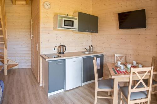 a small kitchen with a table and a microwave at Domki letniskowe Marengo in Lubiatowo