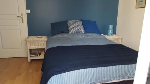 ディエップにあるAppartement Cosy au bord de merの青い壁のベッドルーム1室(ベッド1台付)