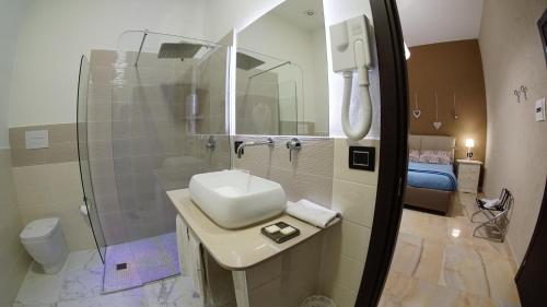 a bathroom with a sink and a shower and a toilet at Beverello Suite in Naples