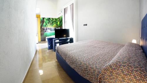 a bedroom with a bed and a desk with a television at Beverello Suite in Naples