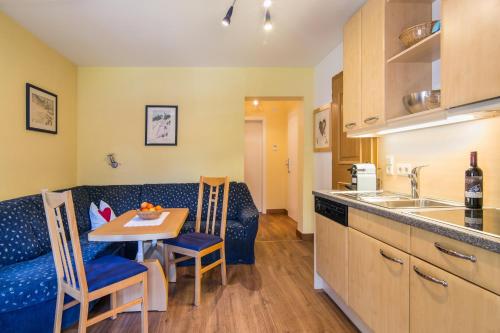 a kitchen and living room with a table and a couch at Am Eschenbichl in Mayrhofen